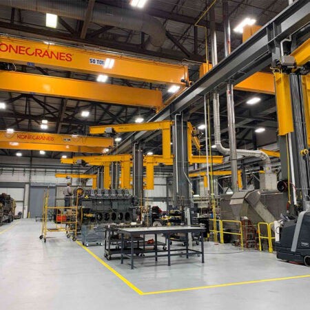 Large yellow cranes inside 165,000 SF engine rebuild center planned, designed and constructed by Robert E. Lamb's Architects and Engineers